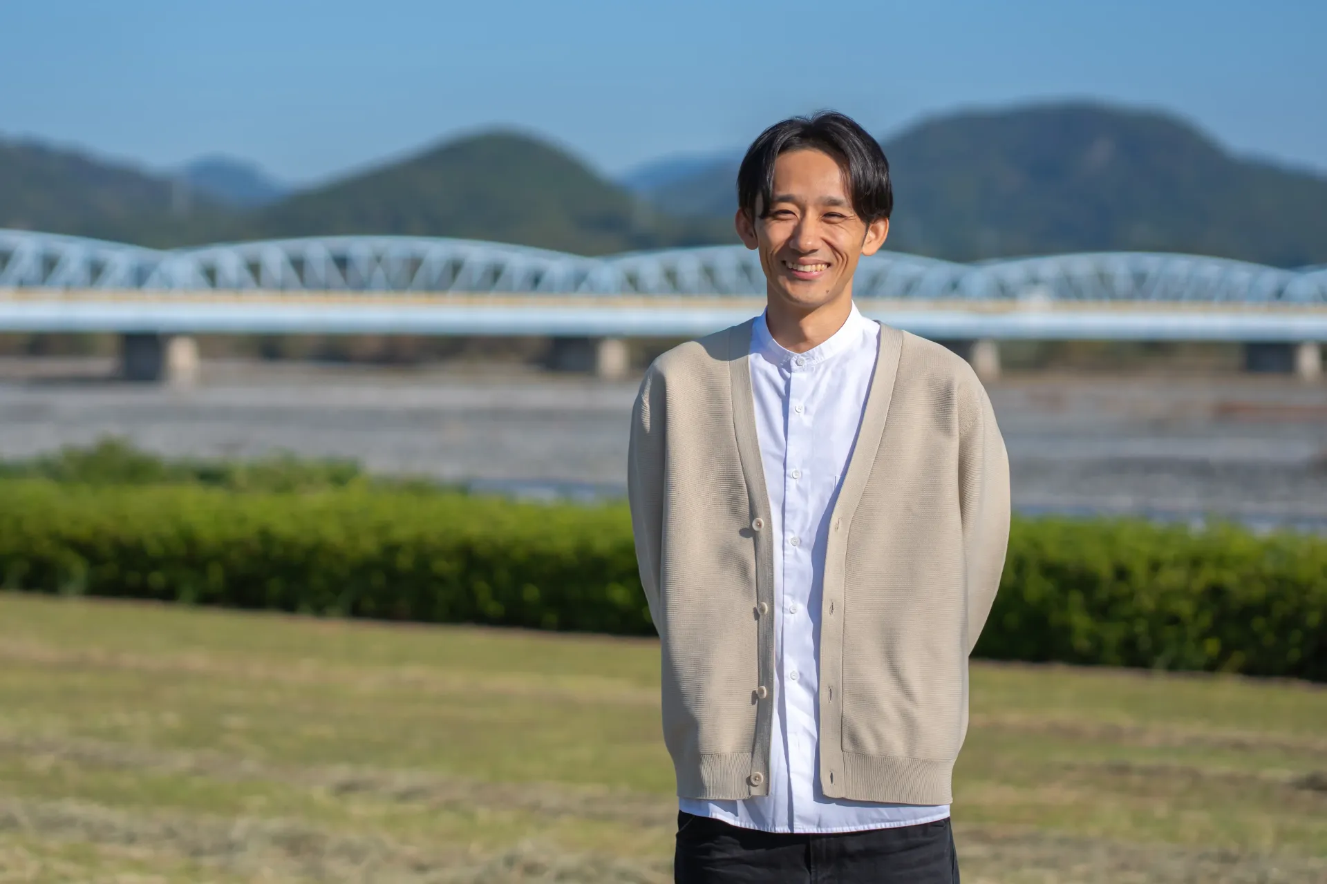 川と橋を背景に立つ人物