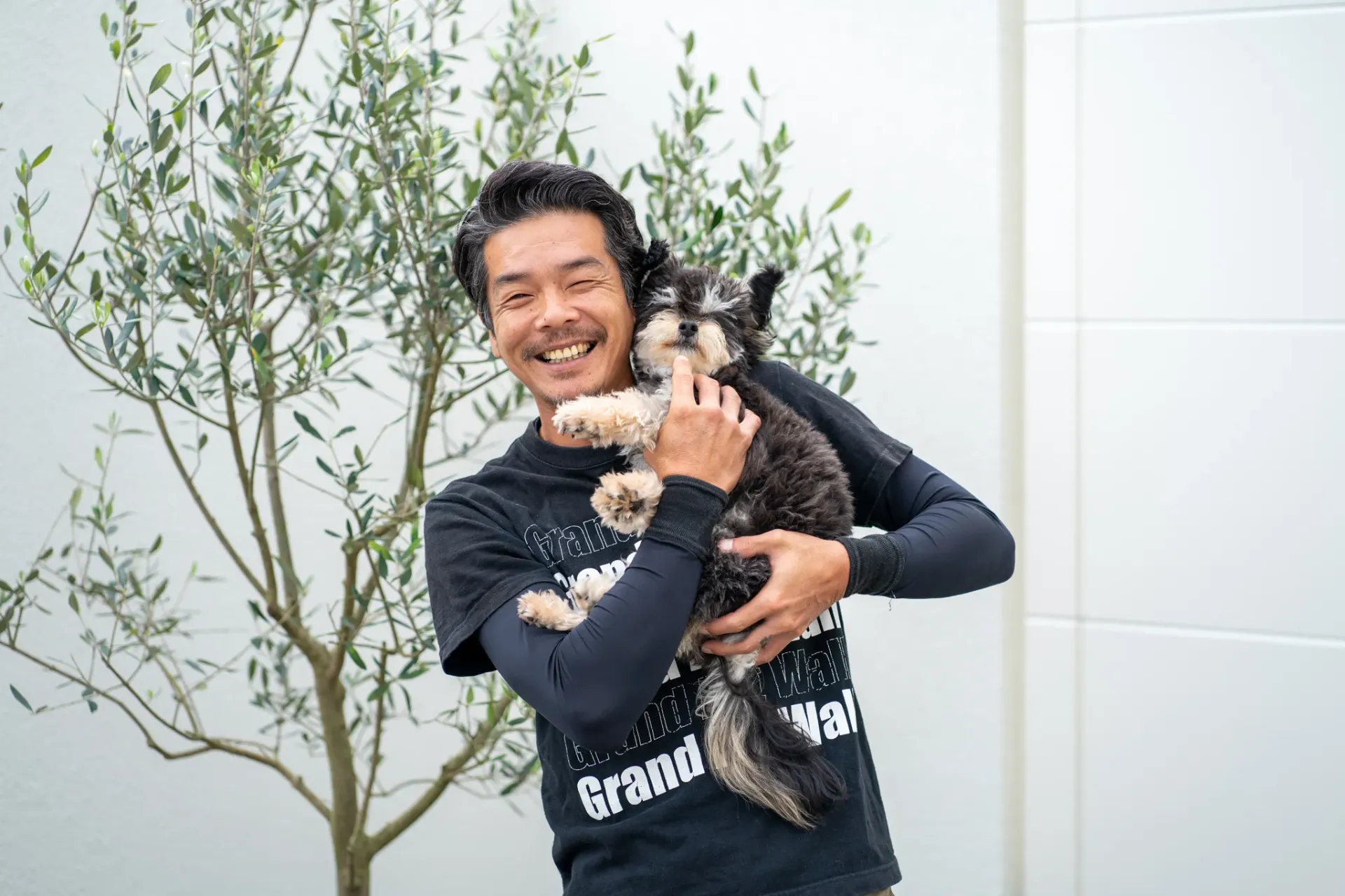 犬を抱えて笑顔の男性の撮影