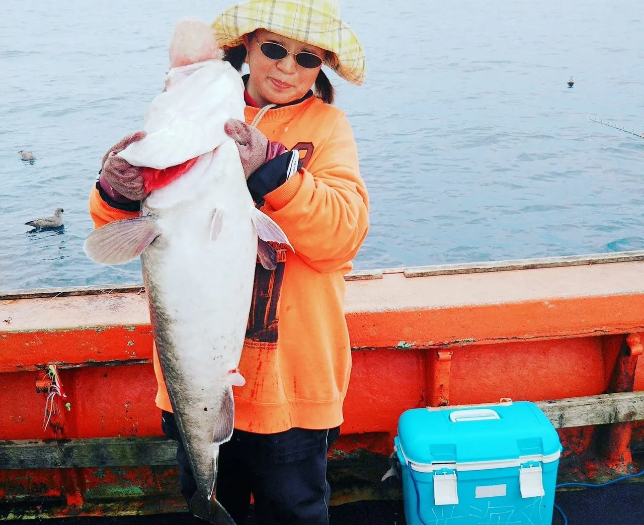 船上で大きな魚を釣り上げた様子
